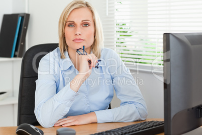 Serious thoughtful looking woman behind her desk Serious thoughtful looking woman behind her desk
