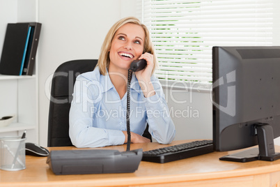 Cheerful businesswoman on phone looking at the ceiling