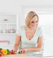 Close up of a young woman looking for a recipe on laptop