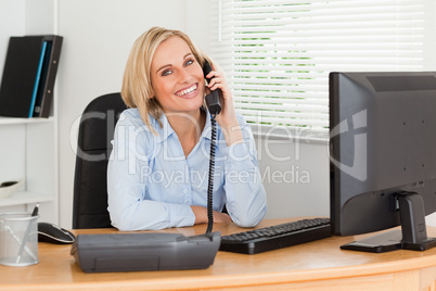 Cheerful businesswoman on phone looking into camera