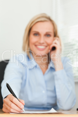 Portrait of a cute businesswoman on mobile noting something look