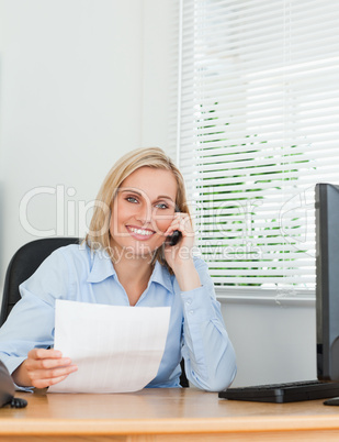 Portrait of a businesswoman looking up from a letter into camera