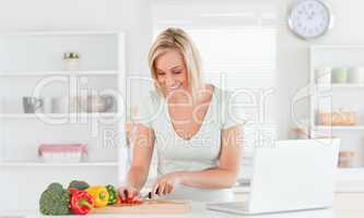 Young woman cutting peppers