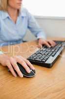 Blonde businesswoman with hands on mouse and keyboard