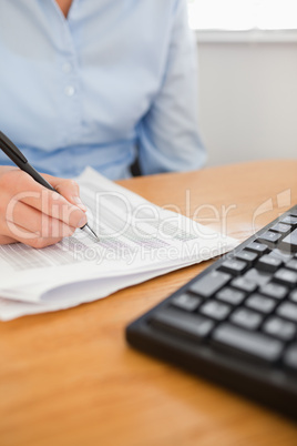 businesswoman with pen going through numbers