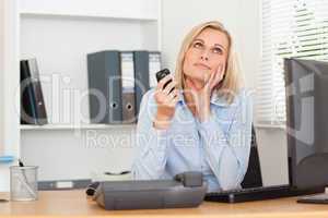 Smiling businesswoman with mobile looking at the ceiling