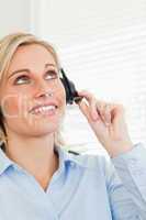Smiling businesswoman with headset looking at the ceiling