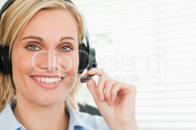 Close up of a smiling businesswoman with headset looking into ca