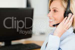 Portrait of a smiling blonde businesswoman with headset working