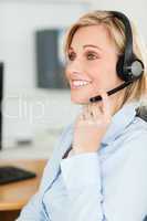 Portrait of a smiling businesswoman with headset looking elsewhe