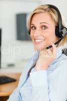 Portrait of a smiling businesswoman with headset lookinginto cam