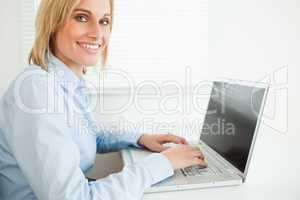 Close up of a gorgeous smiling businesswoman working on laptop l
