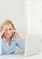 Frustrated blonde businesswoman sitting in front of her notebook