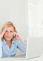 Frustrated blonde businesswoman sitting in front of her notebook