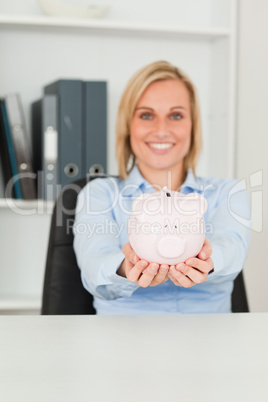 Gorgeous businesswoman holding a piggy bank