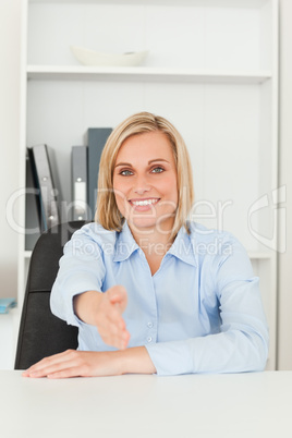 Smiling blonde businesswoman giving hand