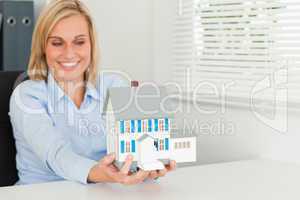 Smiling woman showing model house