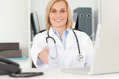 Blonde smiling doctor giving hand