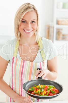 Woman showing a pan with peppers