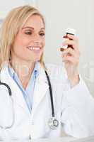 Smiling blonde doctor looking at medicine