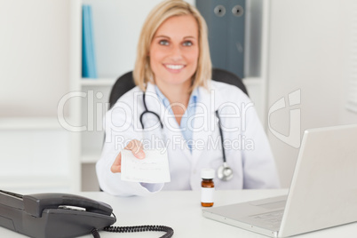 Smiling doctor holding prescription