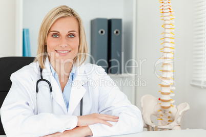 Smiling doctor with model spine next to her