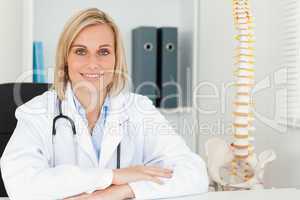 Smiling doctor with model spine next to her