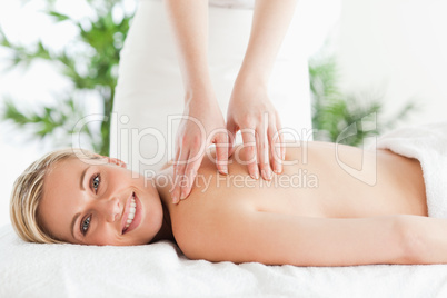 Blonde smiling woman relaxing on a lounger during massage