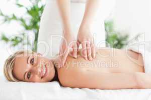 Blonde smiling woman relaxing on a lounger during massage