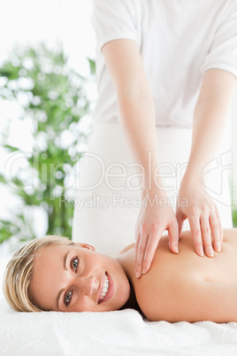 Gorgeous smiling woman relaxing on a lounger during massage