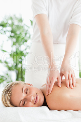 Gorgeous smiling woman relaxing on a lounger during massage with