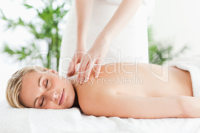 Gorgeous woman relaxing on a lounger during massage with eyes cl
