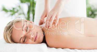 Cute woman relaxing on a lounger during massage with eyes closed