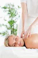 Good looking woman relaxing on a lounger during massage with clo