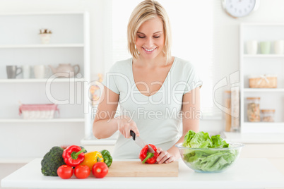 Smiling woman cutting vegetables