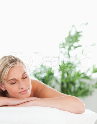 Close up of a blonde smiling woman lying on a lounger with close