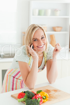 Smiling woman phoning looks into the camera