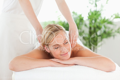 Close up of a smiling woman relaxing on a lounger enjoys a massa