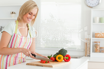 Cute woman cutting red pepper
