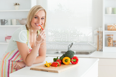 Portrait of a woman eating red peppers