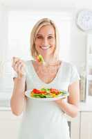 Portrait of a blonde woman eating mixed salad