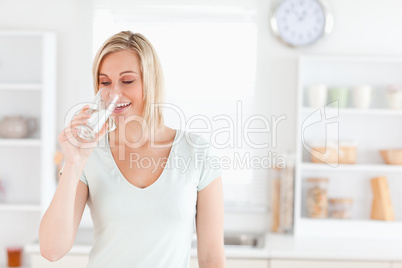 Charming woman drinking waterwhile standing