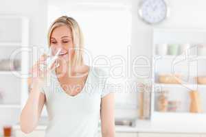 Charming woman drinking waterwhile standing