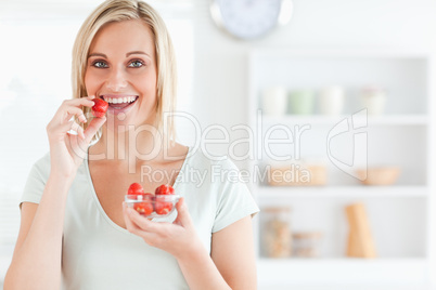 Close up of a young woman eating strawberries