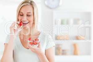 Close up of a enjoying woman eating strawberries