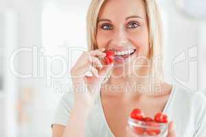 Close up of a woman eating strawberries looking into the camera
