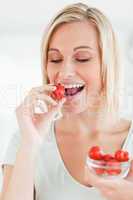 Portrait of a woman enjoying eating strawberries