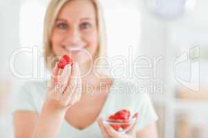 Close up of a woman enjoying eating strawberries looking into th