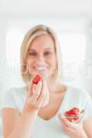 Woman looking at strawberry with pleasure