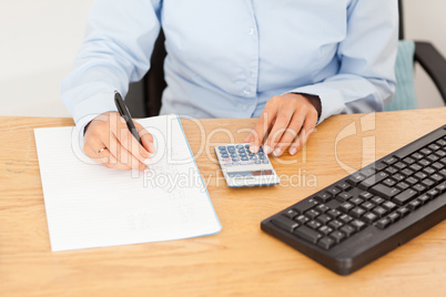 Female accountant writing results on a piece of paper
